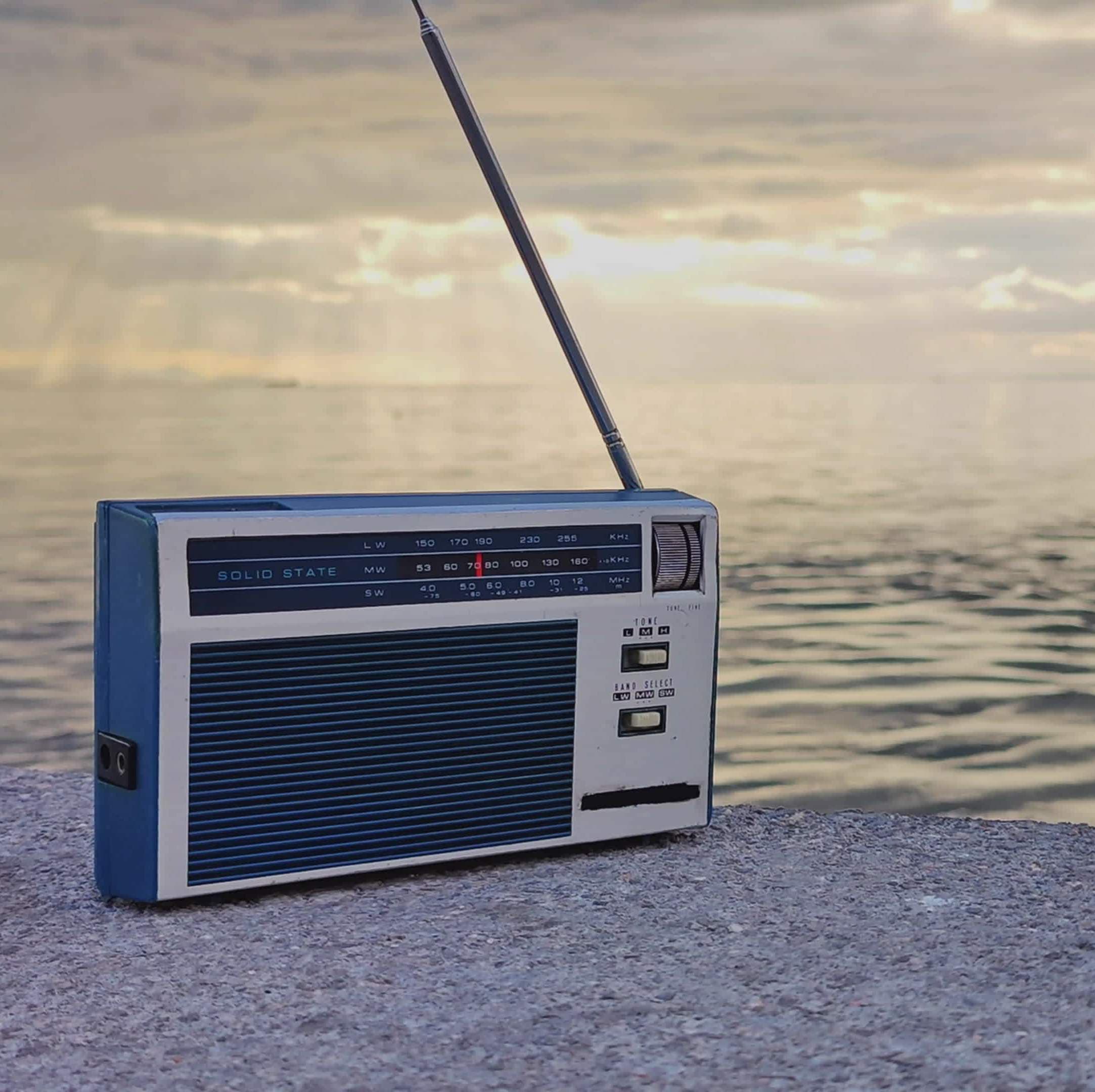 old-style-vintage-manual-pocket-radio-on-a-cloudy-day-at-the-beach-video copy 2